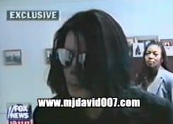 Michael Jackson with sunglasses talking to a report
